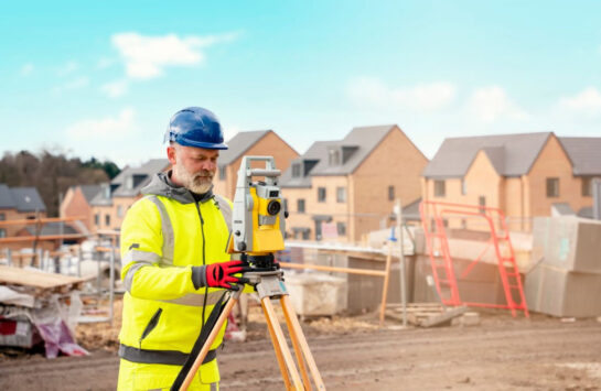 Surveyor with total station in suburban aerea